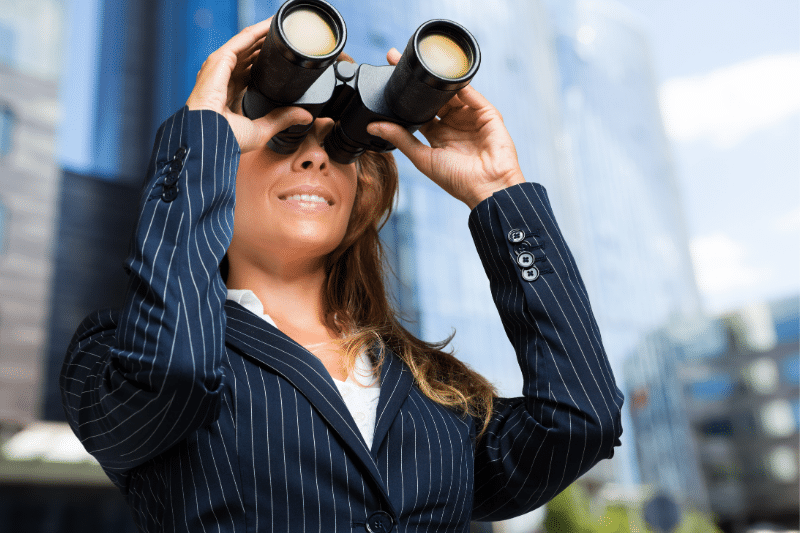 A woman looking thru binoculars